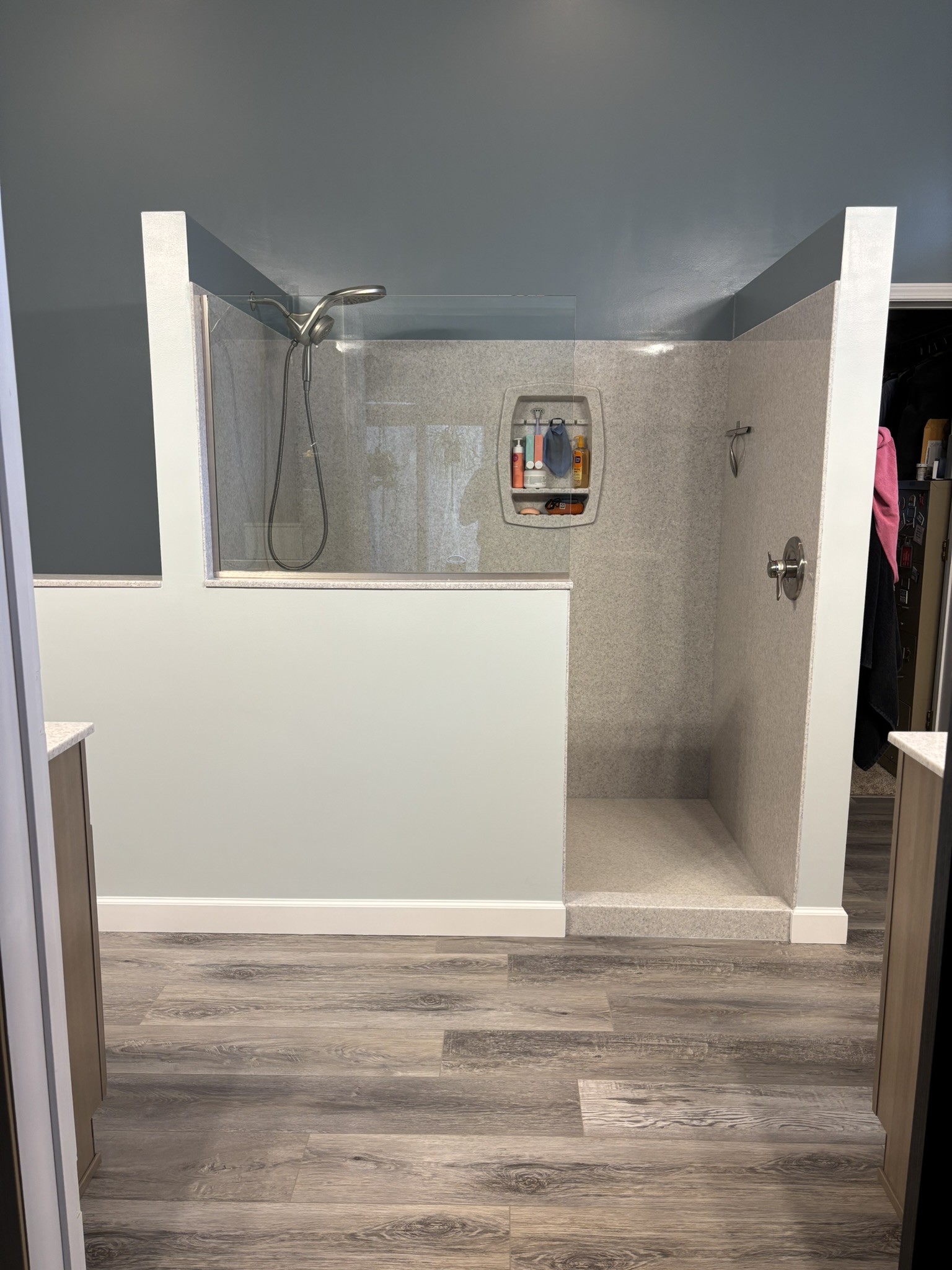 Remodeled bathroom featuring a walk-in shower, updated vanity, modern fixtures, and bright clean finishes